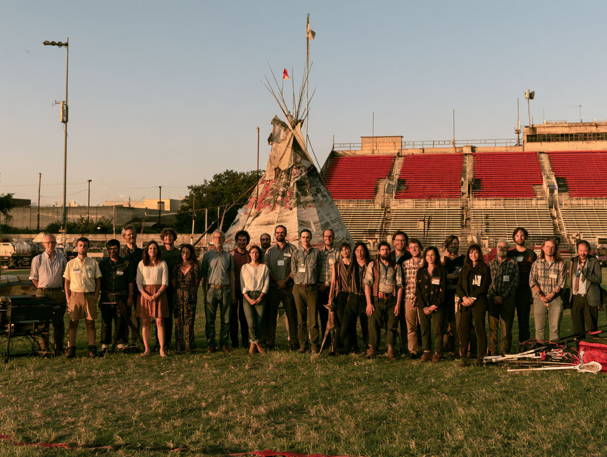 Scholars gathered at the AWI Roundup, beside a teepee and a stadium field